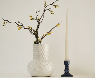Váza s rostlinou a svíčka ve svícnu