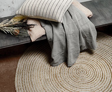 Kruhový koberec, lavice, pléd a dekorační polštářek