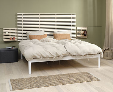 Minimalistická postel s dřevěným postelovým čelem