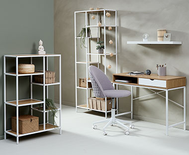 Bílý psací stůl, šedá kancelářská židle a různě velké regály