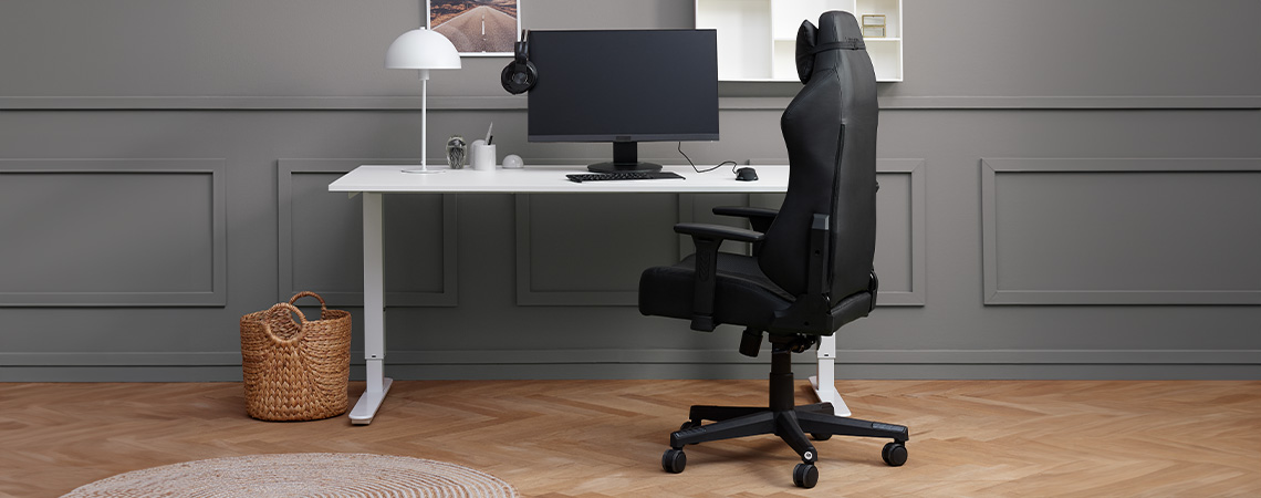 Stylová, elegantní a ergonomická herní židle u stolu s monitorem a headsetem