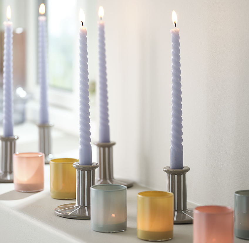 BALDUR twisted candle in MARK candlestick and MATS tealight holder in multiple colours Bright blue twisted candle in candle holder with white stripes, and tealight holders in blue, yellow, and red