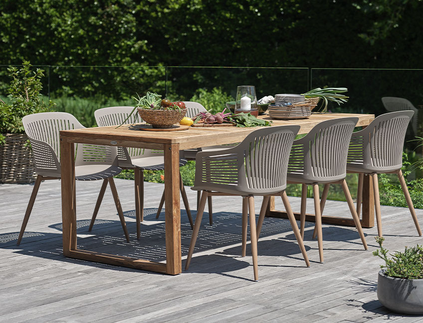 Zahradní stůl z tvrdého dřeva a zahradní židle na terase v zahradě 