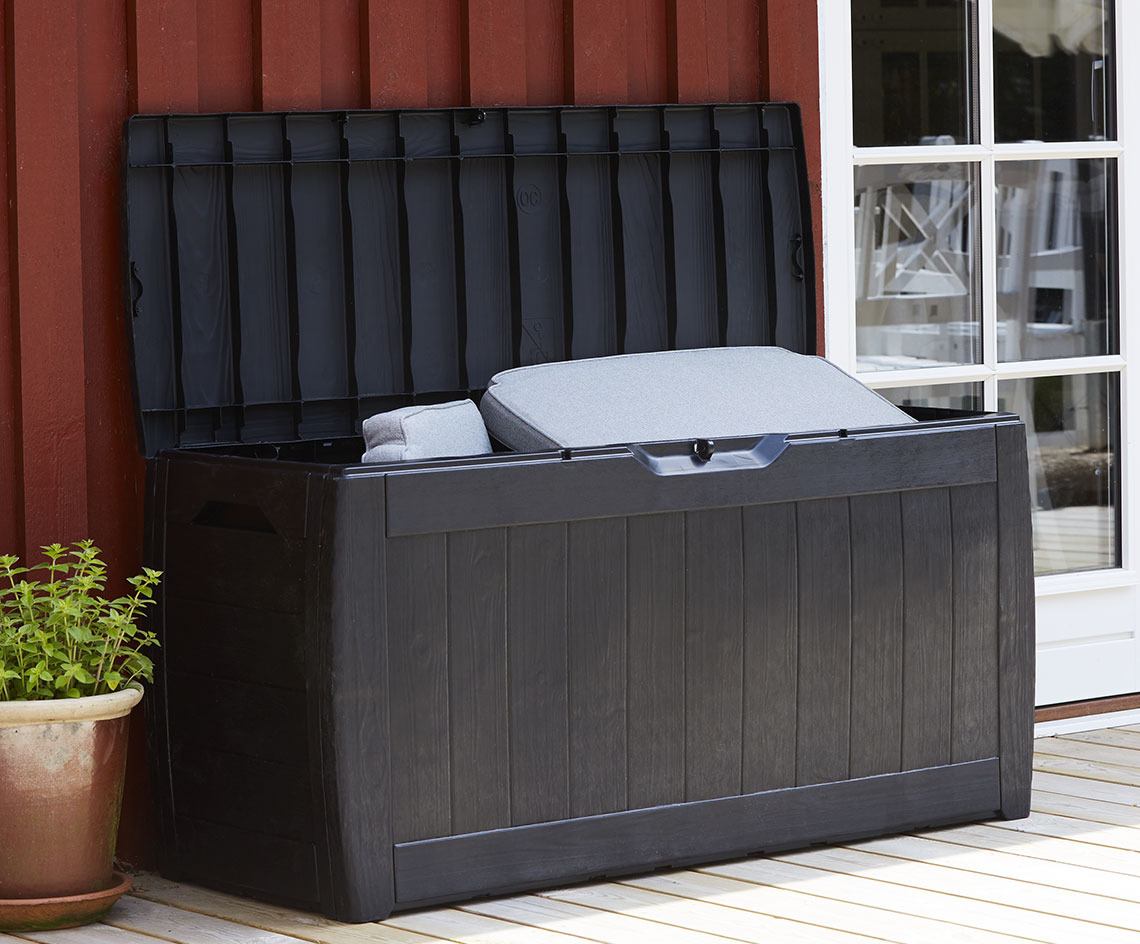 Černý úložný box na polštáře s otevřeným víkem na terase