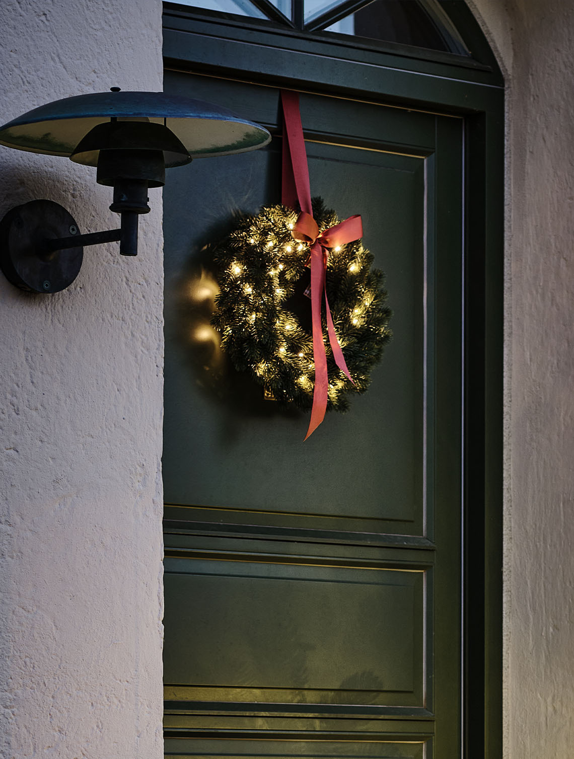 Vánoční věnec FENRIS se zabudovaným časovačem Venkovní vánoční věnec se světýlky zavěšený na dveřích
