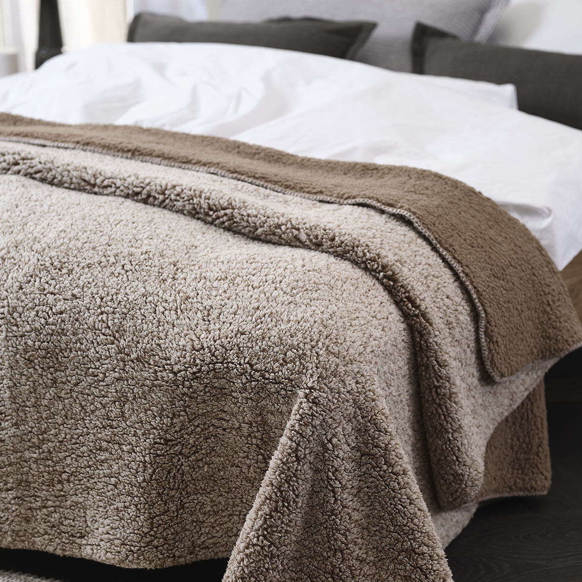Fleecový pléd STORFRYTLE Hnědá fleecová deka na posteli v ložnici