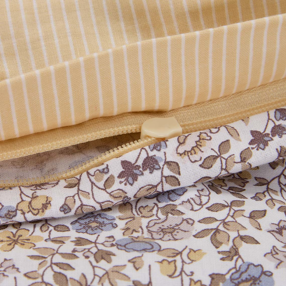 Detail povlečení s květinovým vzorem ve světle fialové a žluté