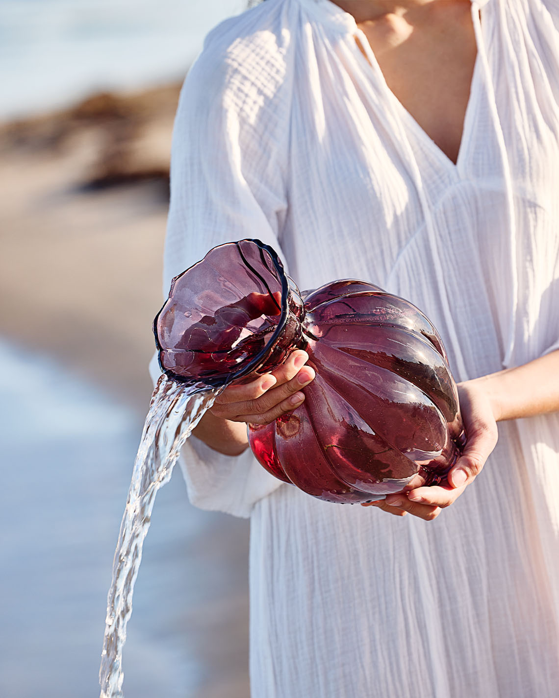 VILMER vase Glass vase in eggplant colour being held by woman on beach