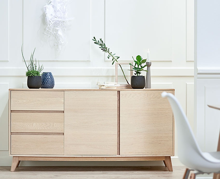 Oak sideboard with three drawers and two doors in a dining room
