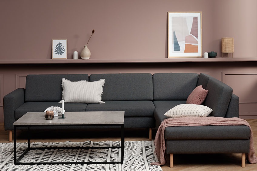 Sofa with chaise end, cushions and throw in a living room