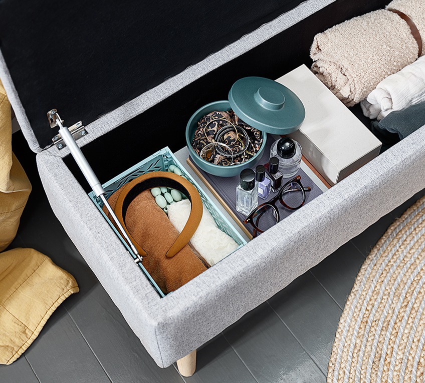 End of bed storage bench with a storage jar, a throw and other items