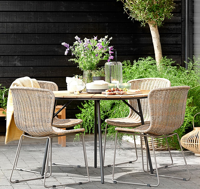 Four HAJSTRUP stacking chairs around the round RANGSTRUP garden table Four stacking chairs around a round garden table on a patio