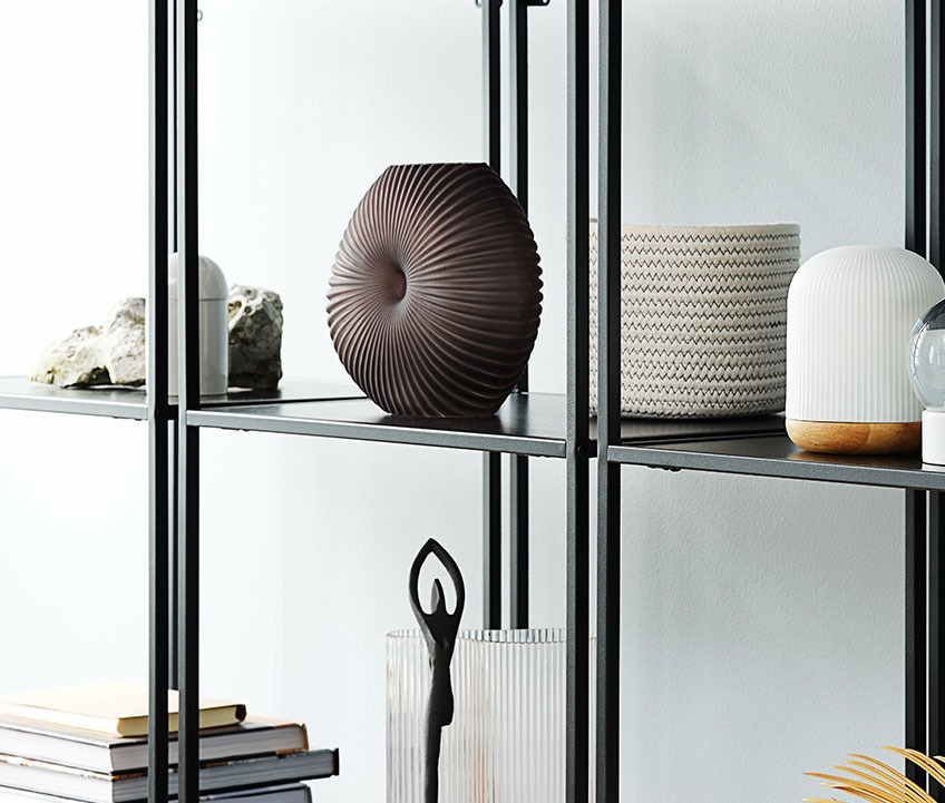 Black vase on a shelf in a bookcase 