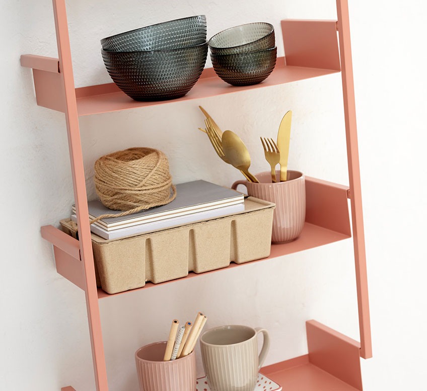 Peach coloured wall shelves with glass bowls, mugs and storage box 