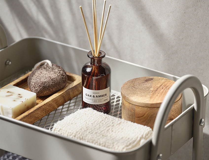 Scented oils, wooden jar and bath sponge place on small console table 