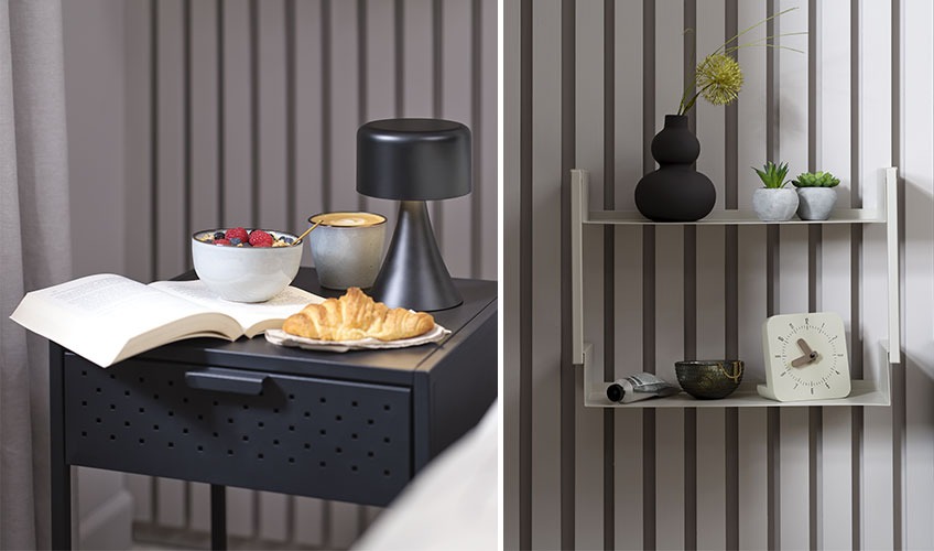 Black bedside table with book and breakfast and metal wall shelf