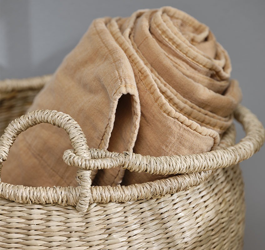 Wicker basket with orange quilted blanket 