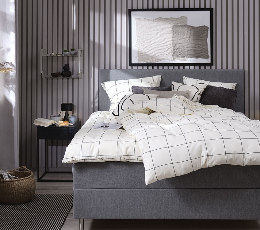 Bedroom with white and black bedlinen and black bedside table 