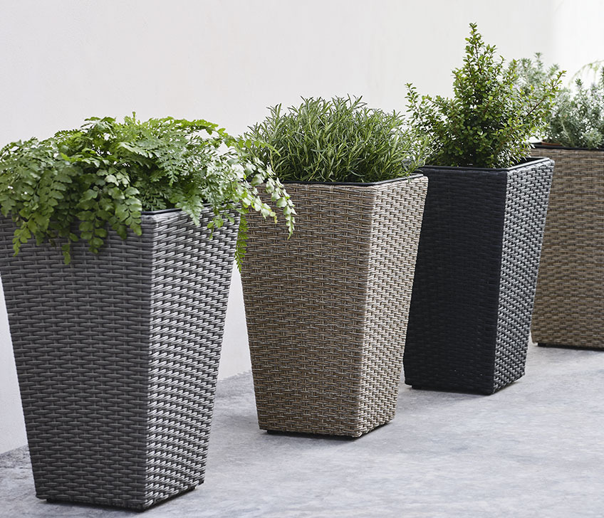 BLOMMOR garden planters are available in grey, brown, black and nature Tall garden planters in a row by a wall