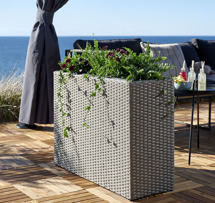 Tall garden planter on a wooden patio 