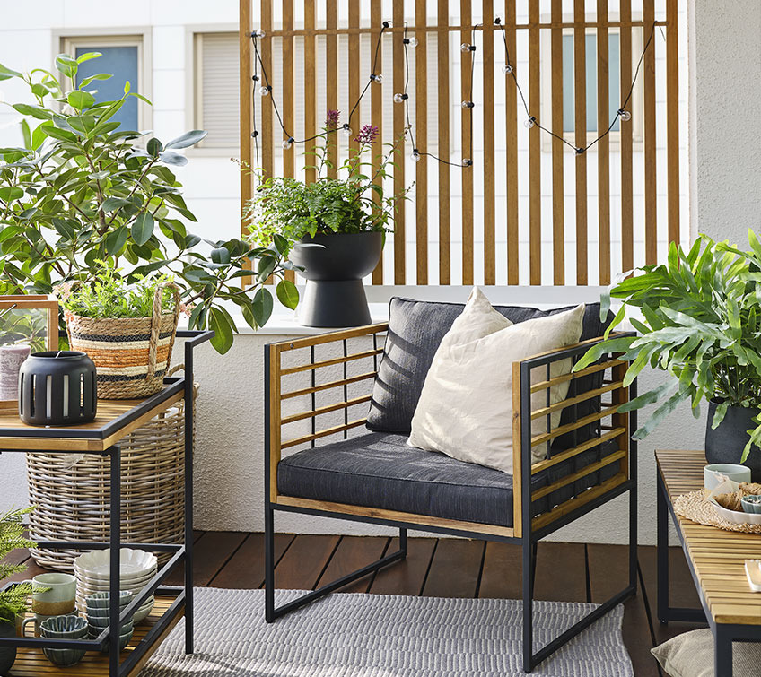 UGILT lounge chair, trolley and bench surrounded by different planters with flowers and herbs Lush balcony garden with planters in different sizes, shapes and materials