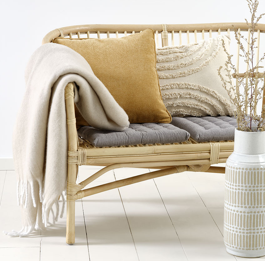 LISELEJE sofa with beige GRAVMYRT cushion, yellow HORNFIOL cushion and TUSENFRYD throw Rattan sofa with beige and yellow cushions and beige throw