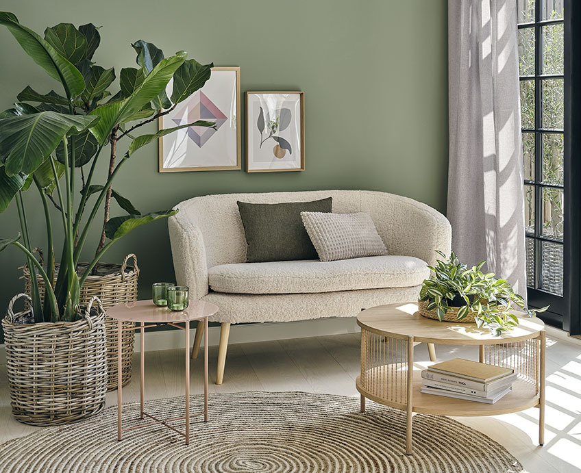 Living room with white sofa, oak coffee table, and green plants