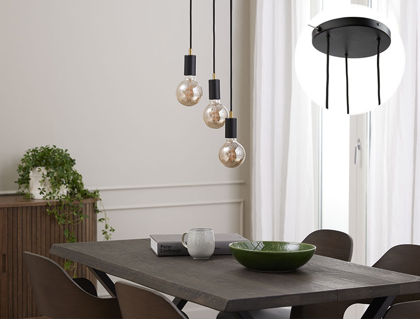 MAGNAR pendant light with TORE light bulbs Black pendant light with large light bulbs above a dinner table