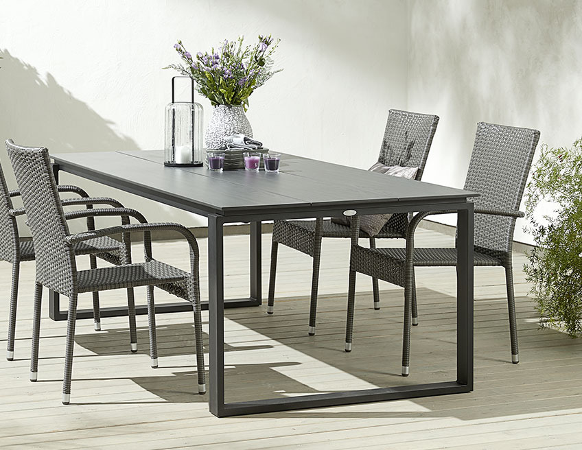 KOPERVIK garden table and GUDHJEM stacking chairs Black garden table with garden chairs on a patio