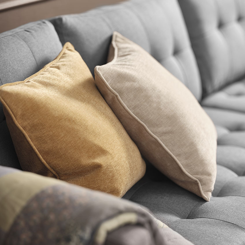 Yellow and beige chenille cushions on grey sofa 