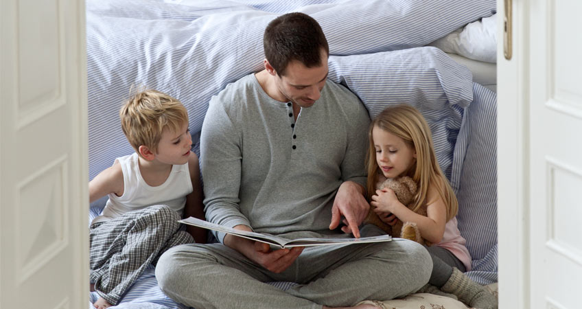 Tatínek čte dětem pohádku před spaním