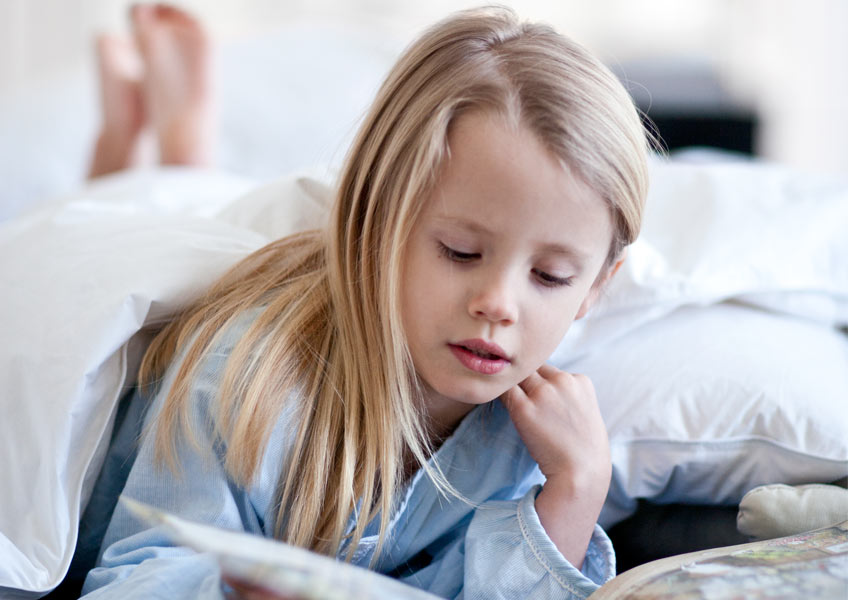 holčička si čte pohádku před spaním