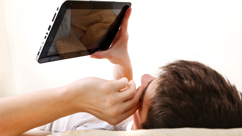 Person with tablet in bed