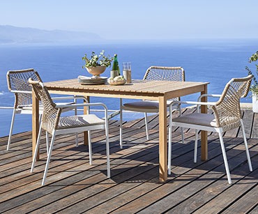 Dřevěný zahradní stůl a zahradní židle na terase
